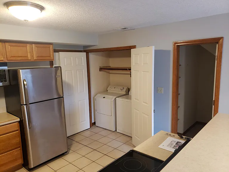 In house laundry room in kitchen off the garage door entrance, pantry shown on the right