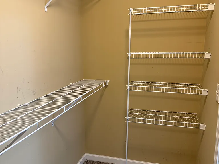 Master bedroom walk in closet with shelving.