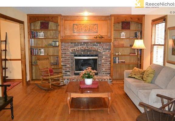 Great room with brick fireplace and built-in book shelves. Hardw