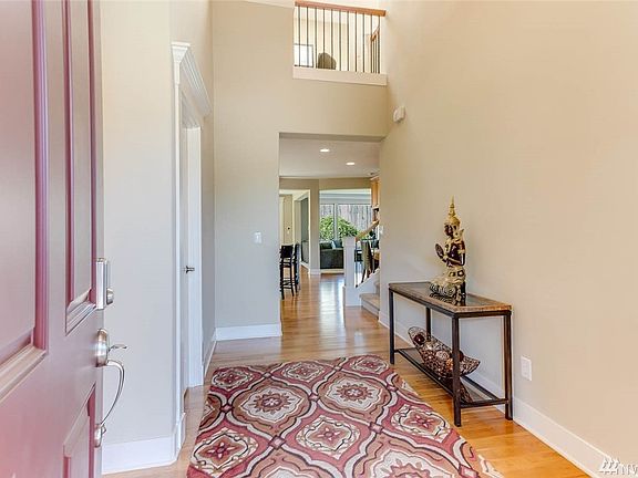 Soaring 2-story entry with large transom window above, hardwoods throughout kitchen and dining spaces, and views of study alcove upstairs.