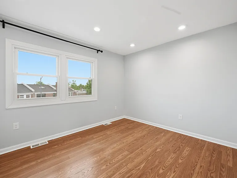 Second Bedroom with Bright Windows and Wood Flooring