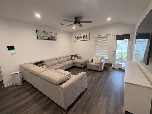 Bright, oversized living room with a ceiling fan and plenty of space for seating, entertaining, and relaxation.
