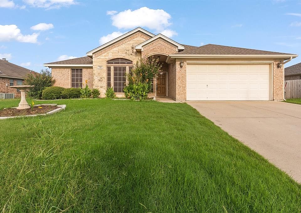Ranch-style home with brick siding, driveway, an attached garage, and a shingled roof