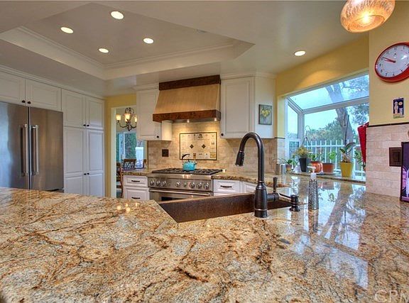 Recessed lighting and tray ceiling with garden window makes this kitchen look stunning!