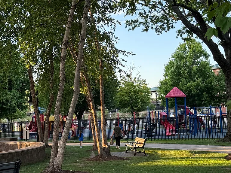 Town Park with playgrounds, by kids splash pad and library.