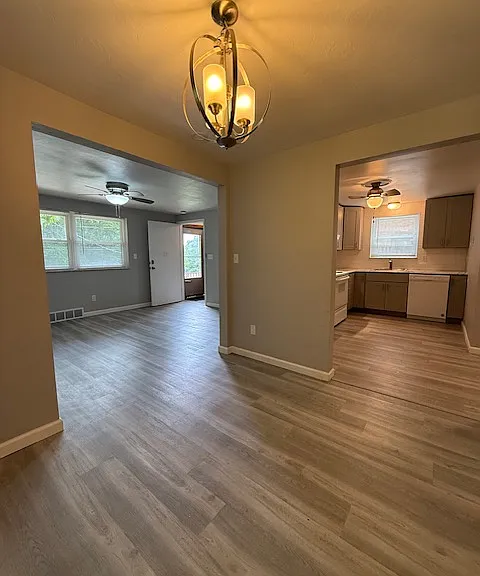 Dining area with living room on left and throughway to kitchen, bedrooms, and bathroom on your right.