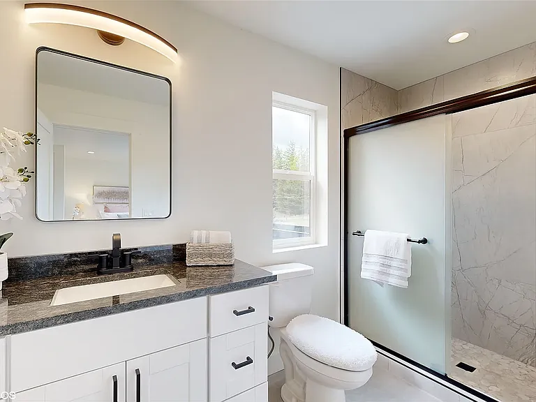 Luxurious ensuite bathroom on the 2nd floor, featuring upscale modern finishes, elegant tile-work, a glass-enclosed walk-in shower, and a clean contemporary design that creates a spa-like retreat.
