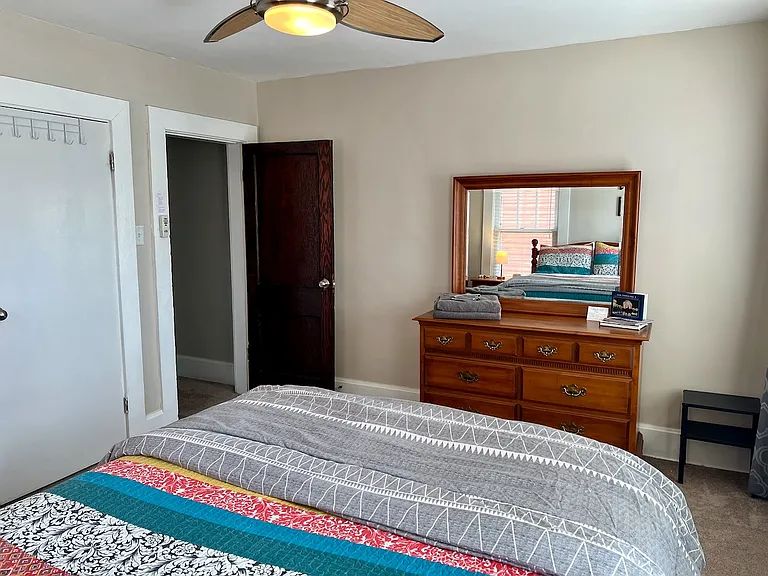 Primary bedroom, queen bed, two dressers and blackout curtains and blinds.