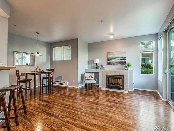 View as you Enter - Light & Bright Open Floor Plan with High Ceilings & Fresh Paint.  Attractive Laminate Floors - Easy to Maintain.  Cozy Fireplace for Cold Winter Nights & Electronic Storage Space.