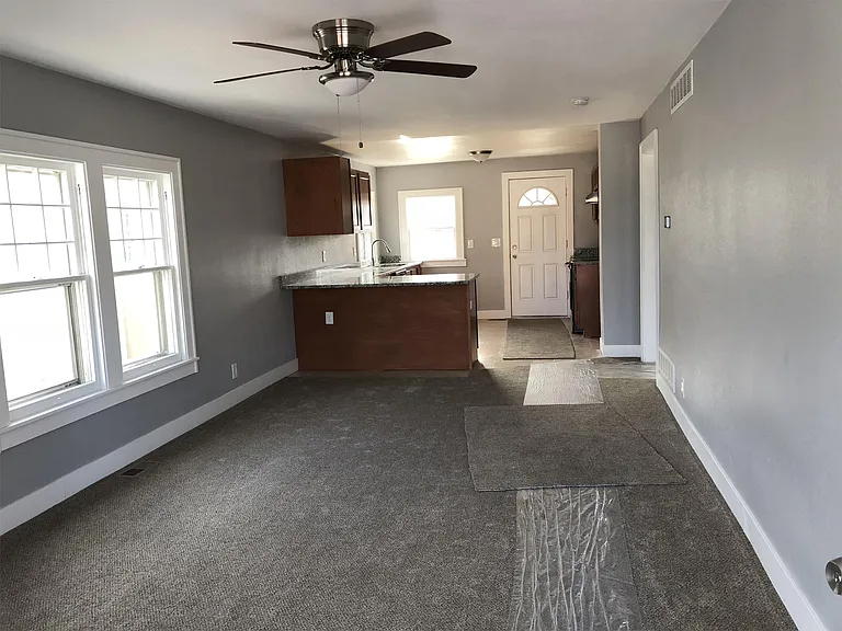 View of living room, kitchen, and back door