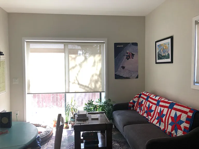 Main living area looking to outside private yard space. Please note, this image has current tenant's furniture, it will come unfurnished