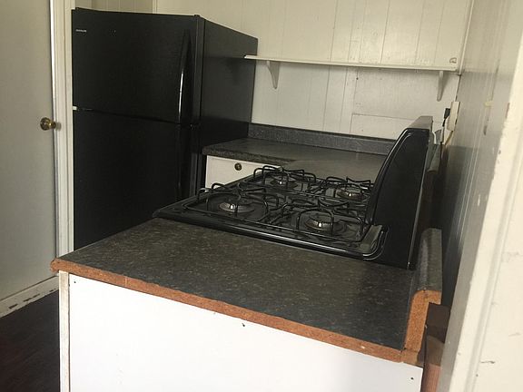 Gas Cook Stove and refrigerator and door to Sun porch and Laundry room.