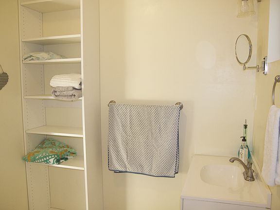 Floor to ceiling adjustable storage shelving, towel holder, sink (with storage underneath)
