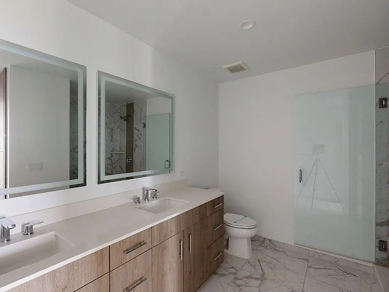 Apartment Bathroom with glass-door shower, large Sink LED vanity mirror and wood-style flooring