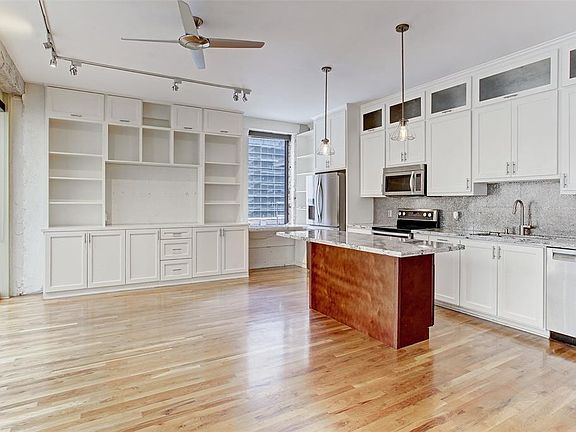 Plenty of room for barstools around the island breakfast bar. Corner unit gives this loft wonderful natural light. Notice all of the counter and cabin