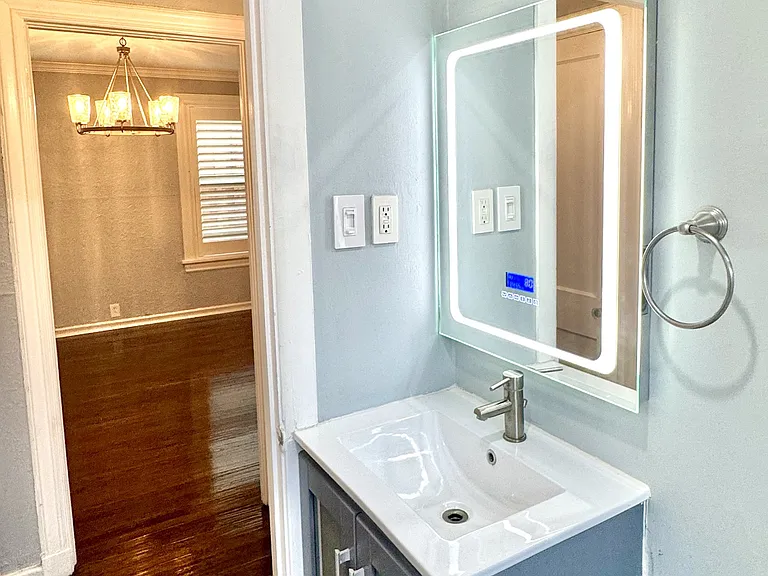 Renovated bathroom with LED light up mirror with Bluetooth speakers. 

View from the bathroom looking into the dining room.