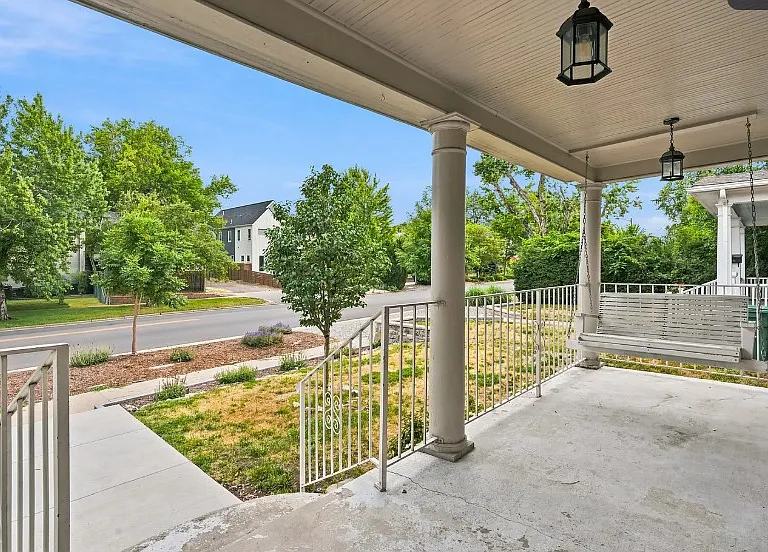 Unfurnished porch but does have a small bistro table with two chairs on it along with the porch swing. Add some flower boxes, rug, pillows and its beautiful!
