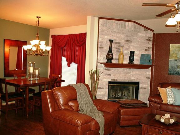 Family room with floor to ceiling brick fireplace, decorator accent walls in living & formal dining. Note updated ceiling fan & chandelier.