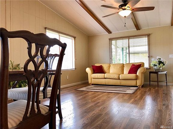 View of the dining and living room with a nice ceiling fan. (Note that the front door is just to the right of the end table.)