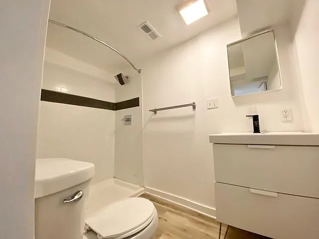 Shower with tile surround and ample cabinet storage.