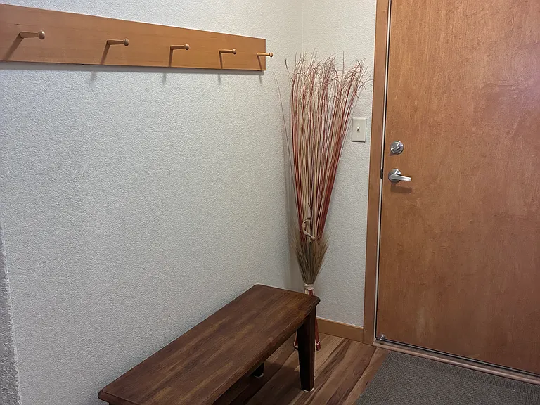 Back entrance with sitting area and coat hooks.