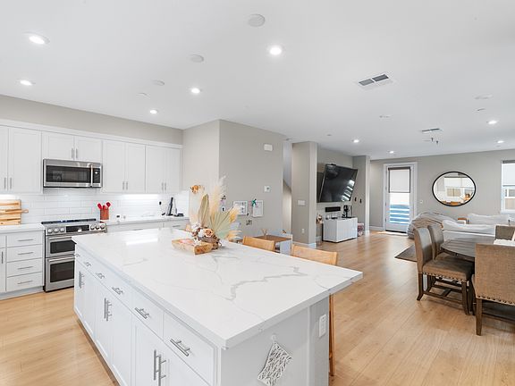 Second floor is the hangout space: kitchen, dining area, living room, and a powder bathroom