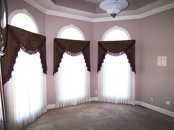 Trio of windows & double-tray ceiling enhance the parlor's quiet elegance