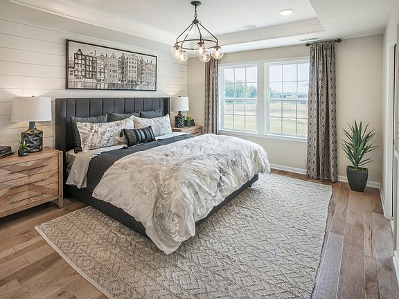 Luxury owner s suite with hardwood floors and large windows