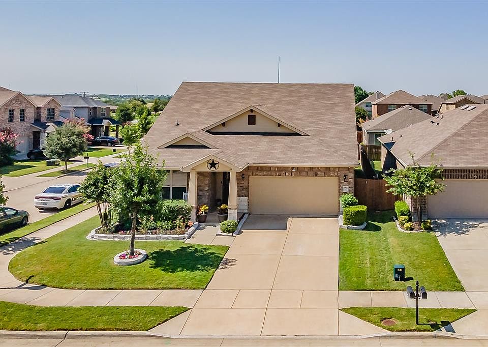 View of front of home featuring a residential view, concrete driveway, a garage, roof with shingles, and stone siding