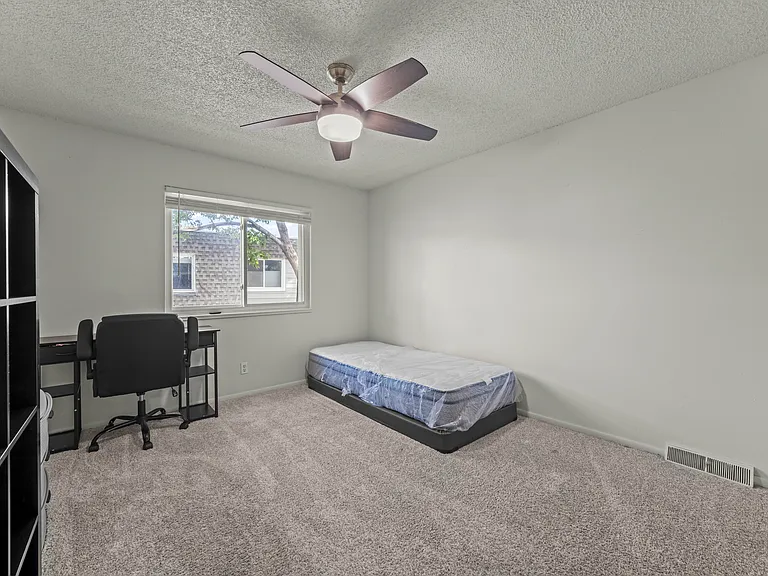 Bright second bedroom featuring a large window for natural light and a spacious closet.