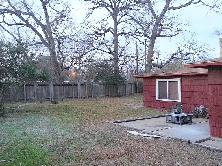 Winter photo of the large rear yard from the fence at the front