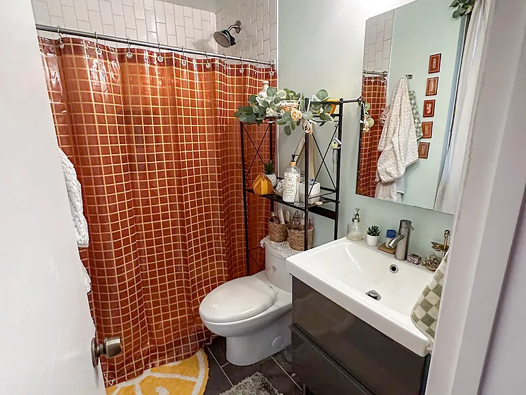 Primary bedroom's en-suite bathroom with slate floor, tiled shower, floating vanity, and medicine cabinet