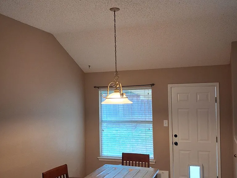 Dedicated dining area with tile floors, overhead pendant lighting, and a large window for everyday meals and gatherings.