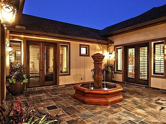 The courtyard's fountain can be accessed from many areas of the home (including guest quarters). The gutters drain into a pipe leading the water to the front street & the potted plants are watered by the sprinkler system making this space worry free.