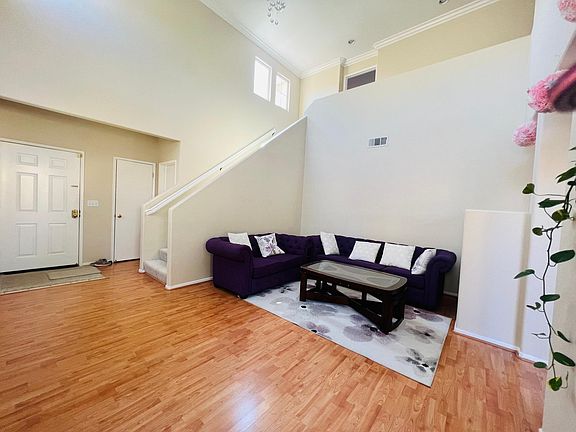 Hall with vaulted ceiling, chandelier, hard-wood floor