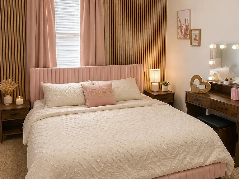 Furnished bedroom featuring a full/queen bed, matching nightstands with lamps, window blinds with curtains, and a vanity desk