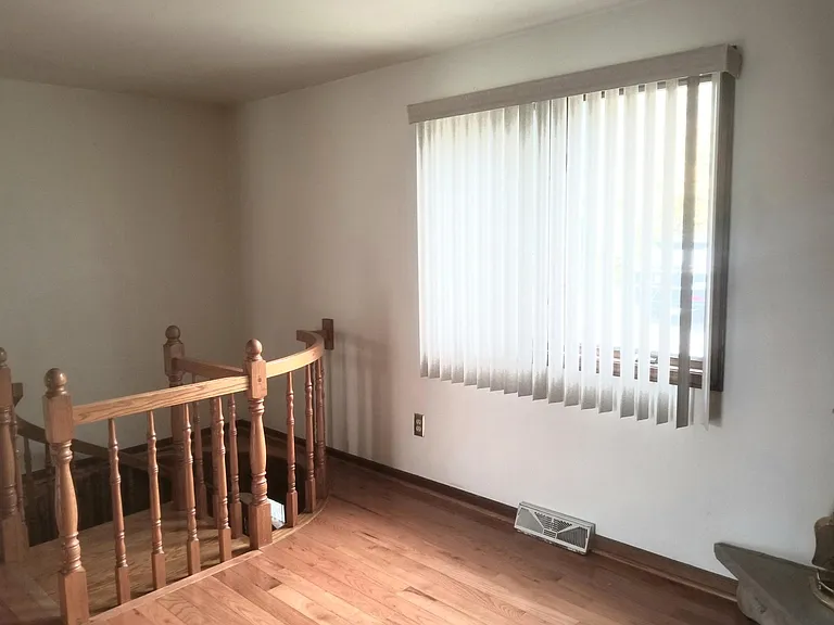 Dining room has custom oak spiral steps leading to the lower level. Custom vertical blinds.