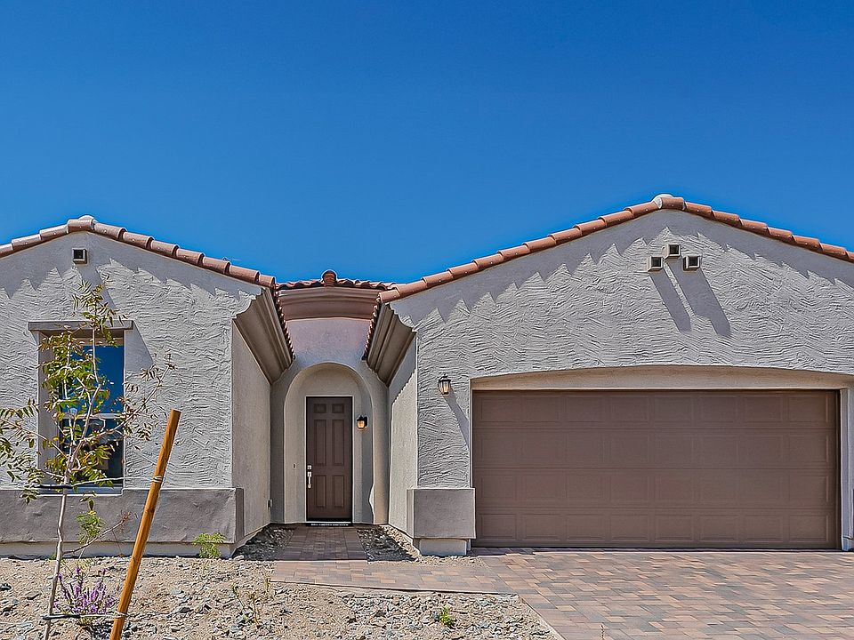 Elegant stucco facade and traditional tile roofing grace this Hacienda at Estrella home, exuding tim