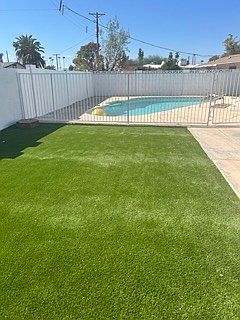 New turf in backyard. Fence surrounding pool.