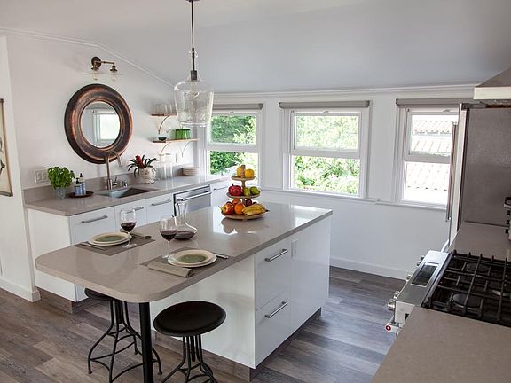 East windows flood the kitchen with light; kitchen island for prep or dining.