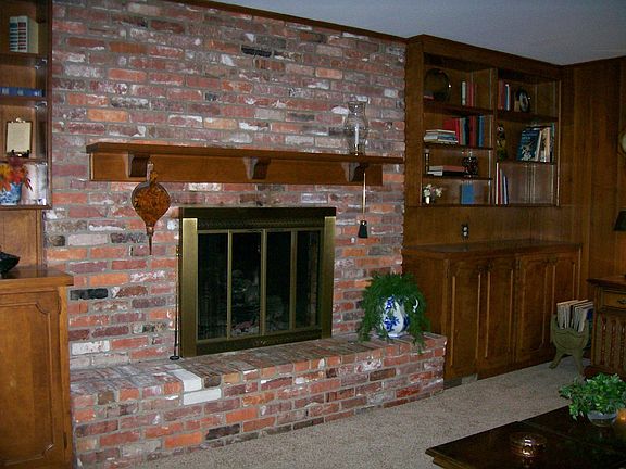 Fireplace and built-in bookcases in den