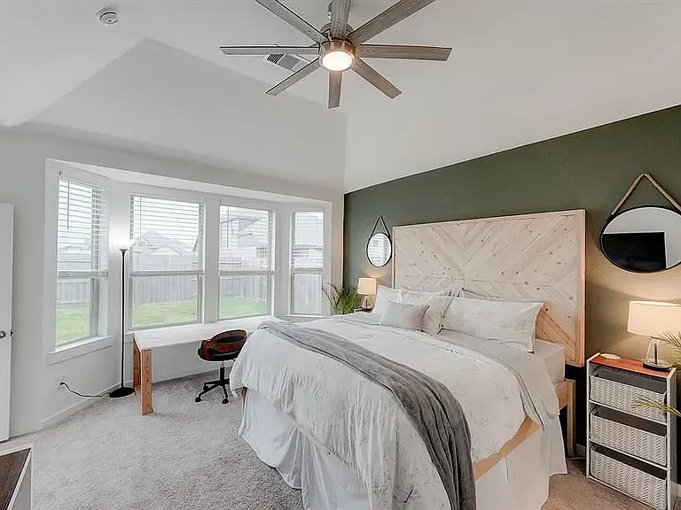 The master suite with large bay windows and upgraded ceiling fan