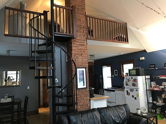 Open concept lower level with spiral staircase to master bedroom and walk-in closet