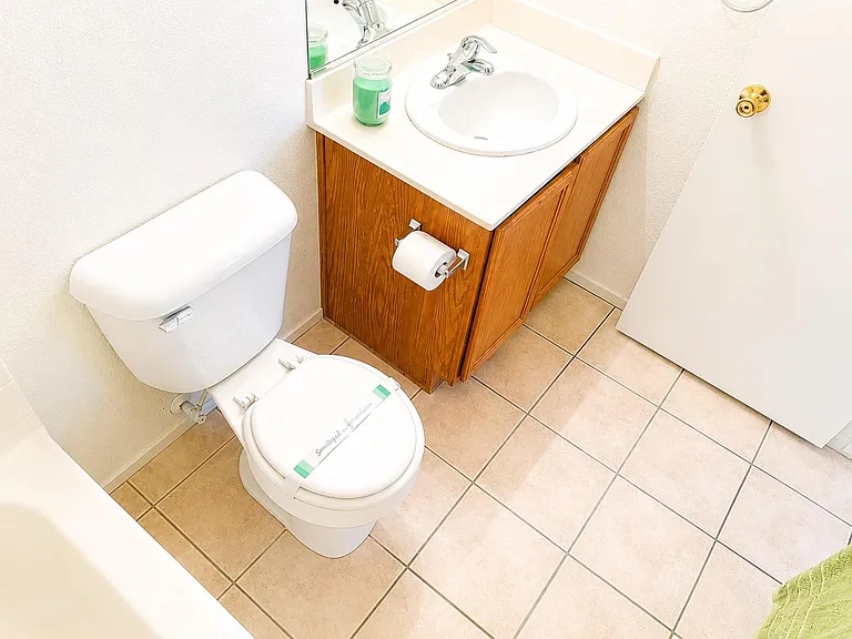Clean full bathroom with tiled flooring, a single-sink vanity with storage, and a tub/shower setup for daily convenience.