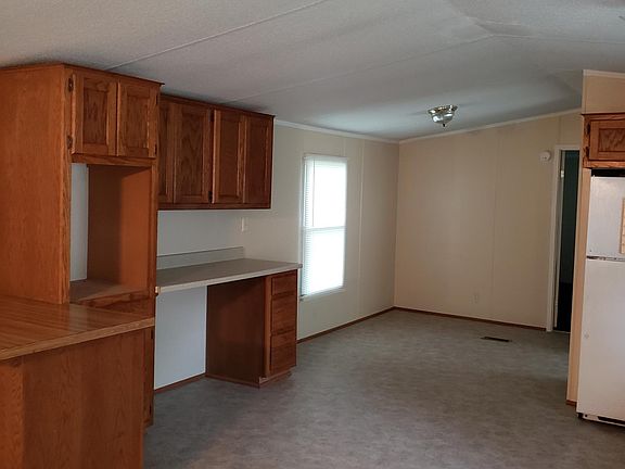 More kitchen cabinets with desk and microwave cabinet. Showing dining area.