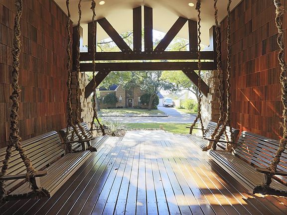 Oversized front porch with recessed lighting and swing bench seating.
