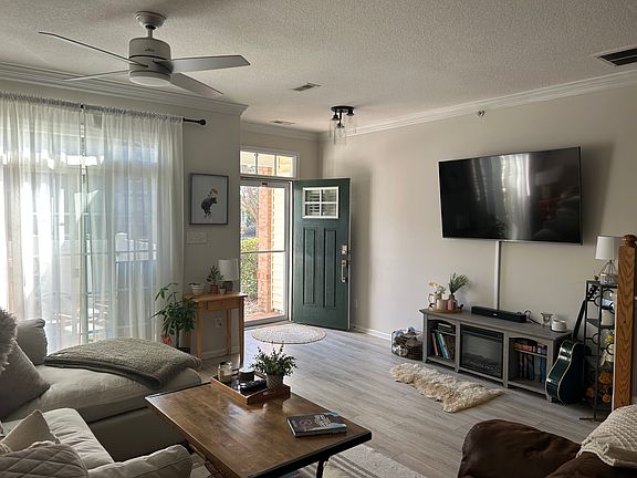 open concept living room and connected front patio with outdoor storage closet