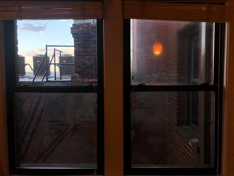 Living room windows at dawn, looking east. Art glass pendant light reflected in right window. Kitchen window has less obstructed view, and includes the lit Basilica at Catholic University at night.