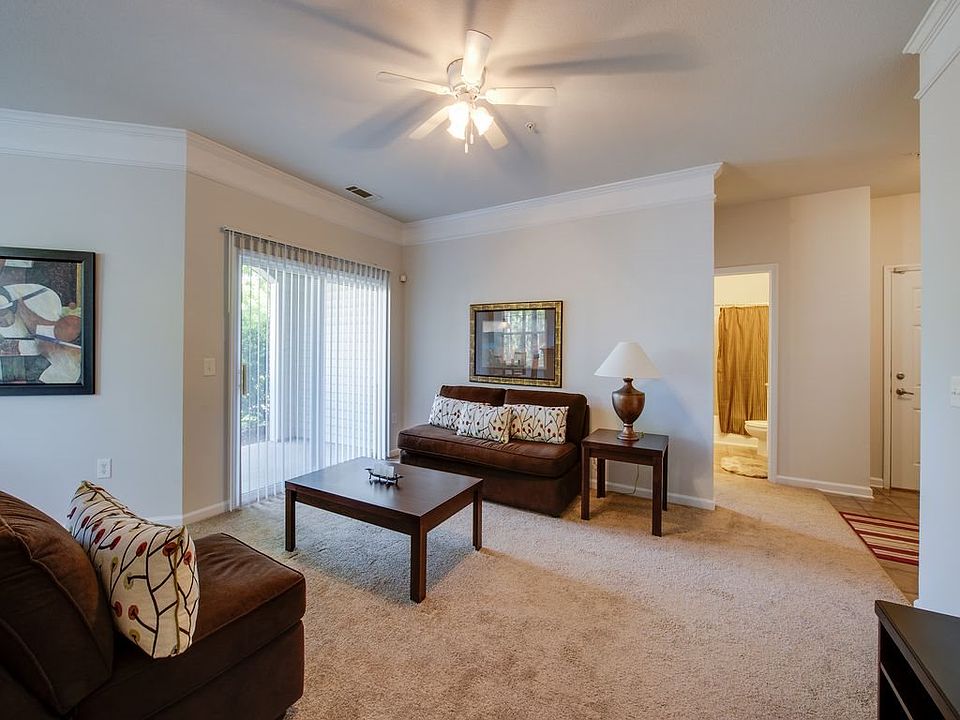 Spacious living room with lighted ceiling fan and crown molding