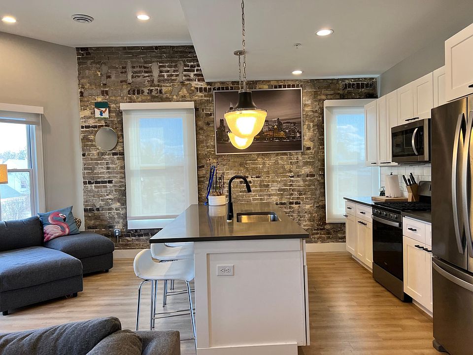 exposed brick! gas range, trash/recycling pull out, gorgeous white window treatment !! stone counters, unique high end lighting take a peek, black hardware on white cabinets w tall ceilings and in unit special STORAGE for bikes or suitcases ...this unit i